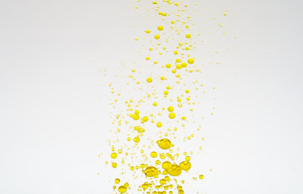 油滴孤立。白色背景上金色的油滴在水中。食品或化妆品成分。图片下载