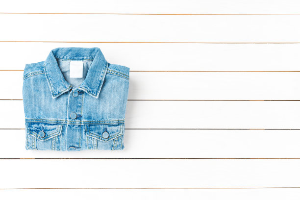 牛仔夹克在白色木制背景与复制空间图片下载