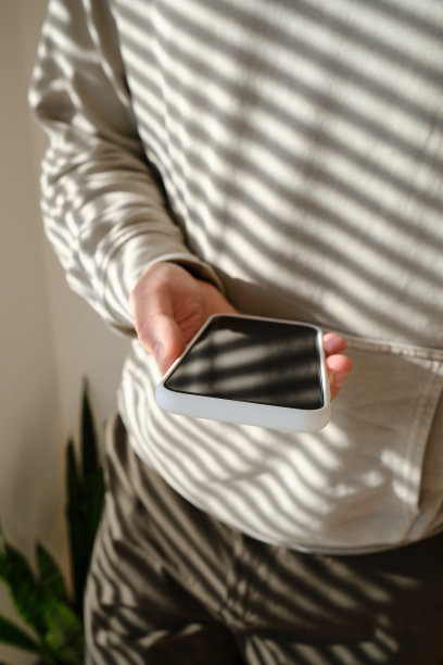 一名男子拿着一部现代智能手机，发短信或使用手机上的应用程序。互联网技术的用户。智能手机的特写。专注于手机屏幕图片下载