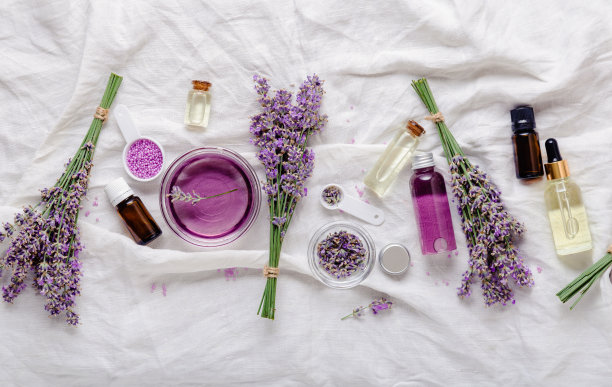 薰衣草护肤化妆品玷污血清和薰衣草花在白色织物上。集天然spa美容产品。薰衣草精油、精华液、身体油、按摩油、液体。平躺图片下载