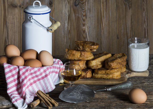 用鸡蛋、牛奶、肉桂和酒等原料制作的torrijas黑色静物。水平的照片。传统的复活节甜点。木制背景。法式吐司图片下载