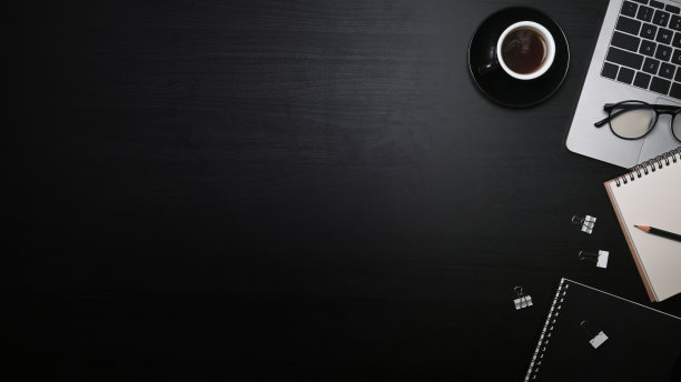 俯视图笔记本电脑，笔记本和咖啡杯在黑色木桌。图片下载