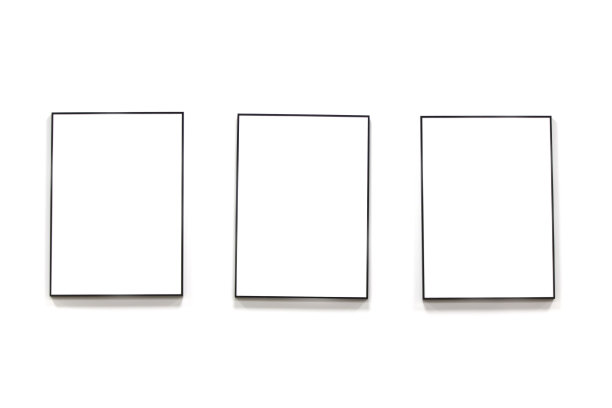 三幅空白的画在黑色的画框里挂在白色的墙上。图片下载
