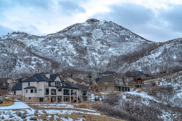 白雪覆盖的大山高耸在风景优美的居民区图片下载