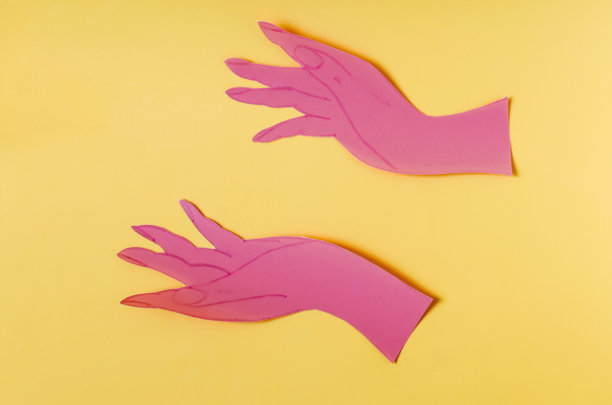 两张用红纸做成的张开的手掌，放在矿井亮黄色的背景上。这个符号由两只手在彩色背景上握住一个空白区域组成图片下载