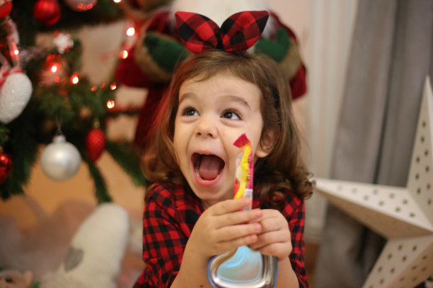 小女孩吃着棒棒糖拍圣诞照片图片下载