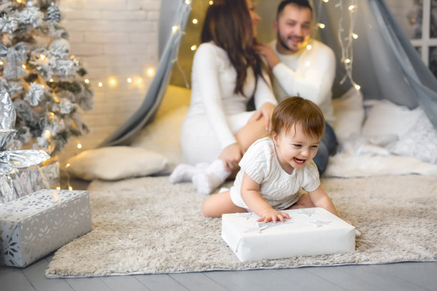 一个小女孩偷偷打开了父母给她的圣诞礼物图片下载