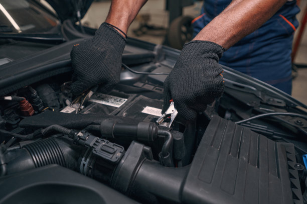 多民族汽车修理工将测试夹安装到汽车电池上图片下载