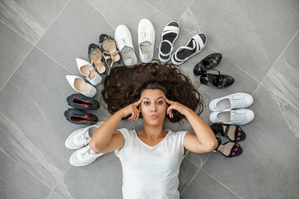 女士考虑选择哪双鞋。图片下载
