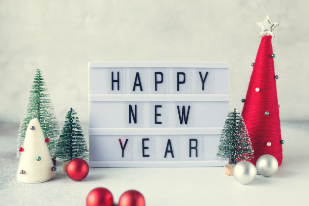 灯箱与文字新年快乐与纱线包裹圣诞圆锥形树。新年的庆祝活动。的着色图片下载