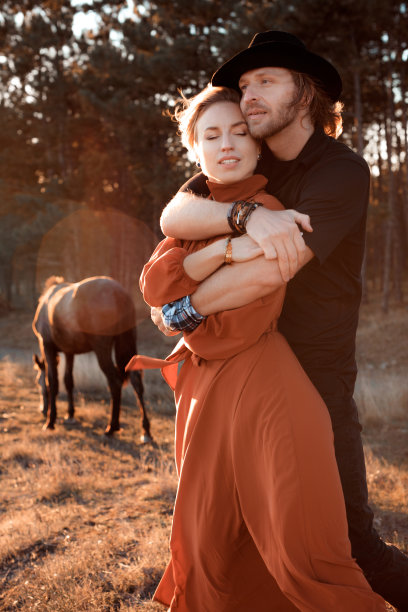 一对幸福恩爱的夫妻，在马场的夕阳下图片下载