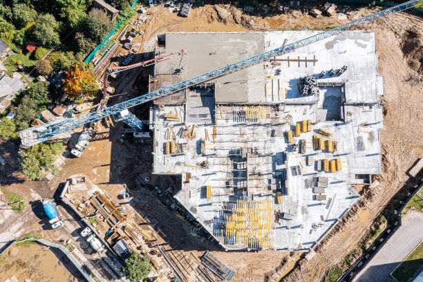 新的多层建筑正在建设中。建筑工人将未干的混凝土浇注到楼板上。空中俯视图图片下载