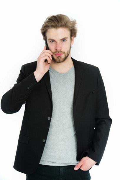 留着胡子的年轻男子穿着正装，正在使用手机图片下载