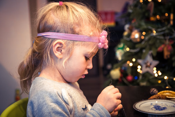 可爱的小女孩在家里装饰圣诞树的玩具图片下载