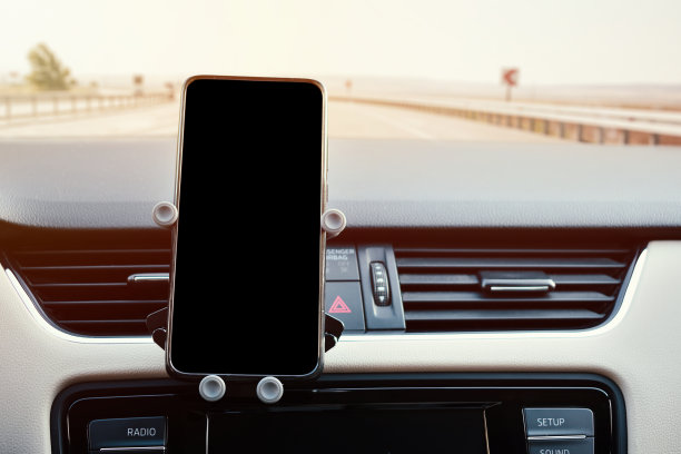 固定在车内通风格栅上的手机架和一部手机的黑屏图片下载