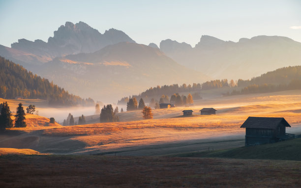 Alpe di Siusi (Seiser Alm)高山草甸，美丽的雾蒙蒙的日出在背景与萨索伦戈和Langkofel山脉和塞塞达山，南蒂洛尔图片下载