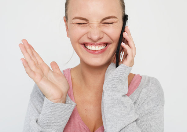 快乐的女性一边在手机上聊天一边庆祝成功图片下载