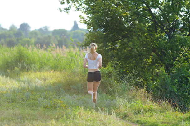 年轻美丽的女人跑步展示，压胃锻炼训练穿着上衣图片下载