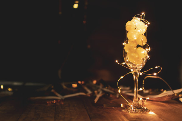 年末概念。一杯香槟，里面有葡萄，还有节日装饰图片下载