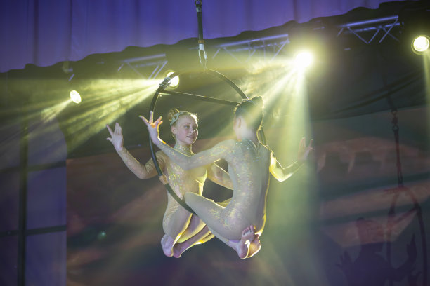 杂技演员的表演。两个女孩在空中表演杂技。图片下载