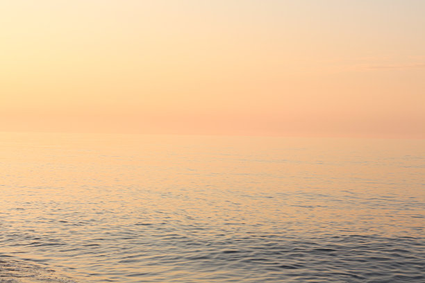 平静的海洋或海水在美丽的温暖的日落颜色图片下载