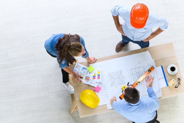 建筑项目工程师团队会议的俯视图。建筑师与施工经理在办公会议现场讨论设计图。建筑的概念图片下载