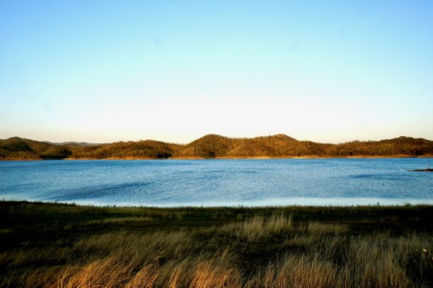 午后太阳对蓝色湖泊及其前景的影响图片下载