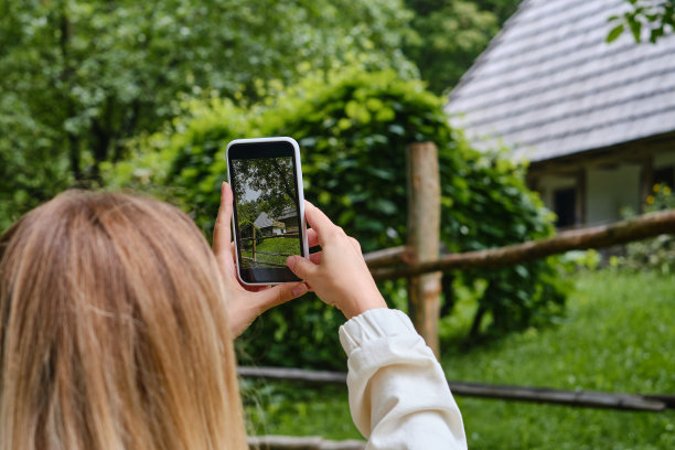 女孩手里拿着手机，在公园里拍下大自然的照片，并在社交网络上分享。专注于手机屏幕。用你的智能手机制造记忆。手机特写镜头图片下载