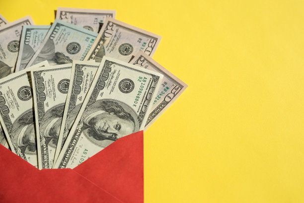 一叠美元钞票装在一个打开的红纸信封里。新美元，美钞，现金概念。次级黑色经济概念。信封的工资。贿赂与经济犯罪图片下载