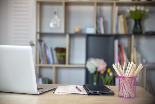 学生概念桌。笔记本电脑用于考试学习，书本放在课桌上，供学生在家在线学习。台式笔记本、笔记本、书、写字板、铅笔放在木桌上。图片下载