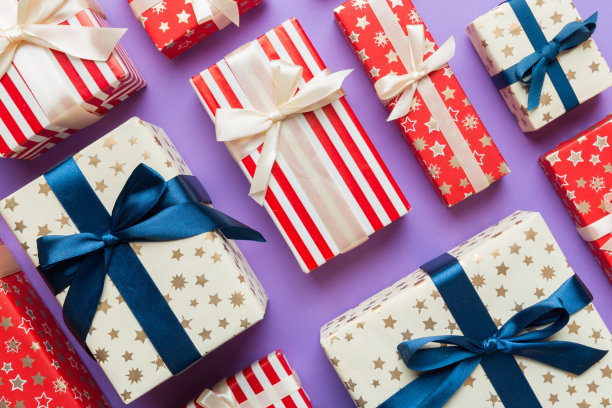 许多圣诞礼品盒用彩纸装饰在桌子上，俯视图关闭。许多人赠送新年礼物图片下载