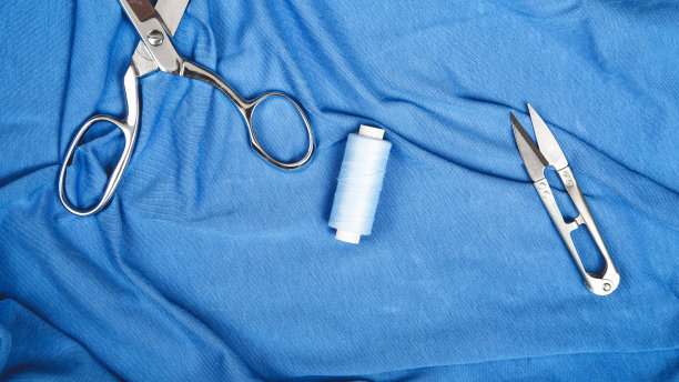 顶视图蓝色织物与线轴，裁剪剪刀复制空间图片下载