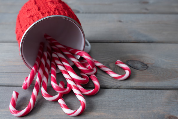 拐杖糖和红色针织马克杯。圣诞节背景与复制空间。图片下载