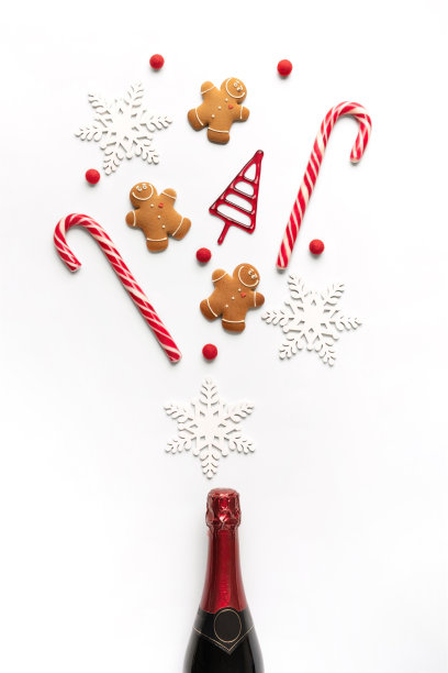 白色背景上有圣诞装饰的香槟瓶。平的。方的概念。图片下载