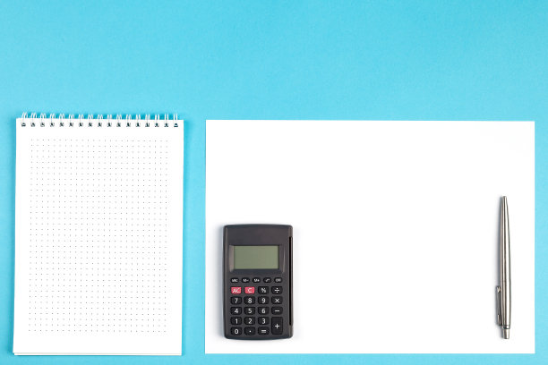 工作区顶视图。办公桌，有办公用品和计算器。顶视图，白色和蓝色背景图片下载