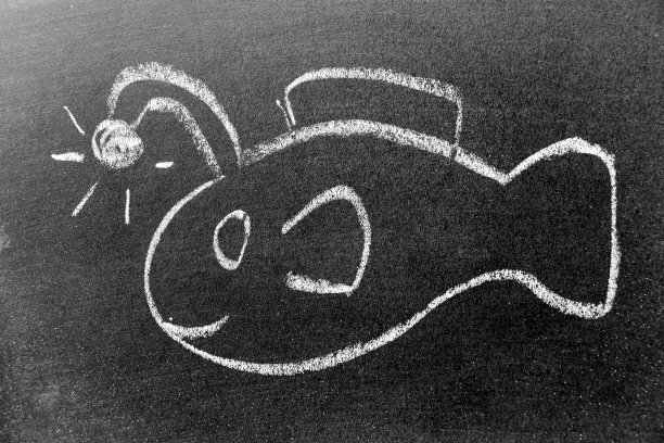 白色粉笔手绘的钓鱼者鱼或灯笼鱼形状的黑色板背景图片下载