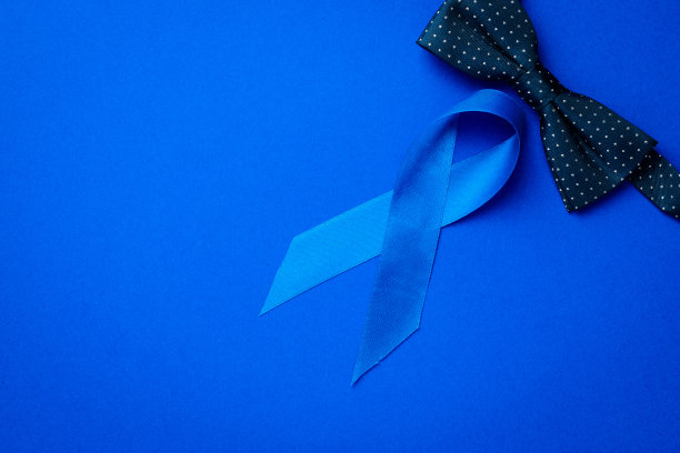 前列腺癌意识。蓝色的丝带，时尚的领结孤立在深蓝色的背景。11月前列腺癌男性健康意识。医疗保健国际男人父亲节图片下载