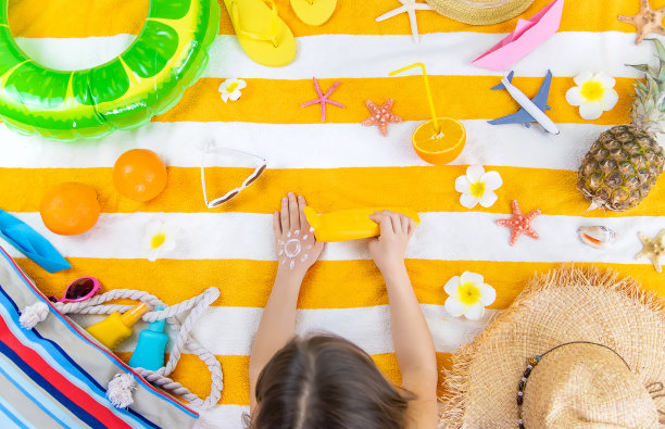 一个小女孩在她的皮肤上涂抹防晒霜。有选择性的重点。图片下载