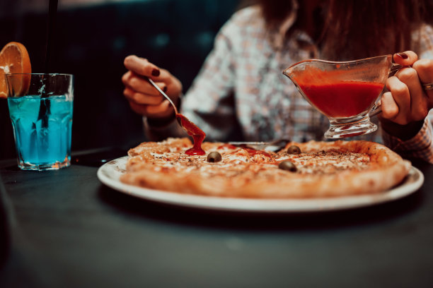 一名女商人在午餐休息时吃披萨的特写照片。有选择性的重点图片下载