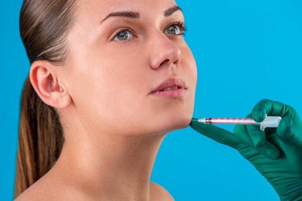 一个皮肤光滑没有皱纹的女孩的脸可以拍出漂亮的照片。注射器旁贴脸，美容美发。戴着手套的手。特写肖像。护肤美容理念，外科学，青春图片下载
