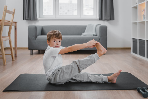 男孩在家里的客厅里健身。做伸展运动。图片下载