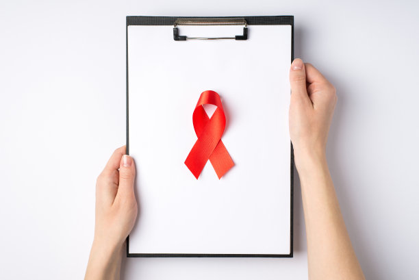 第一人俯视图照片的女性手握写字板与纸和红色丝带象征艾滋病意识孤立的白色背景图片下载