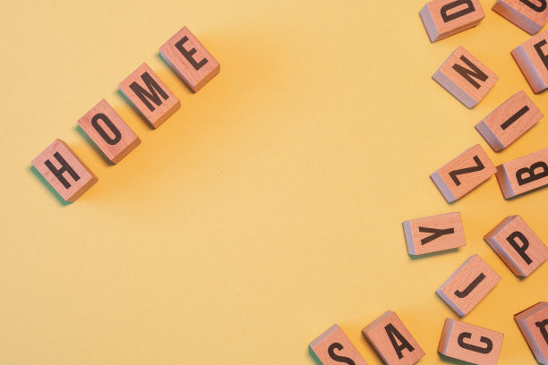 “家”字取自一堆木制字母块，带有黄色背景和复制空间。图片下载