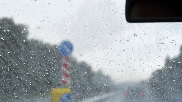从车上看。由于下雨，挡风玻璃湿了。即使下大雨，路标也清晰可见。图片下载