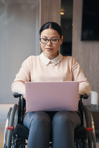 患有偏瘫的女商人在家使用笔记本电脑图片下载