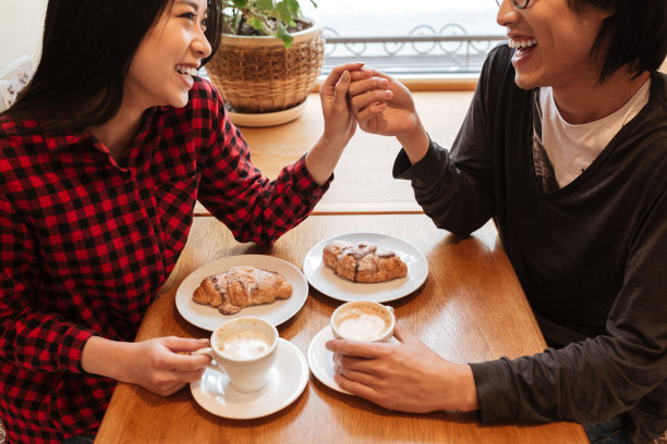 一对幸福的年轻情侣坐在咖啡馆里的裁剪照片图片下载