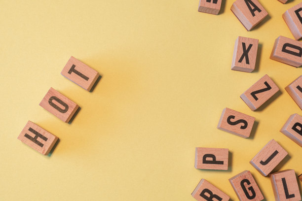 热字从一堆木制字母块与黄色背景和复制空间。图片下载
