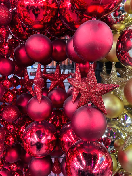 圣诞树上的球和星星装饰在红色，栗色或深粉红色和金色挂在圣诞装饰商店图片下载