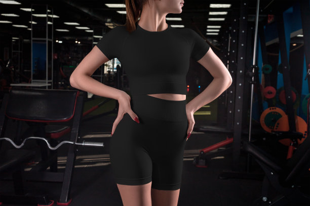 一件黑色紧身衣，短t恤，短裤在一个运动女孩在体育馆的背景模型。图片下载