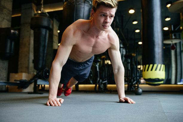 赤裸着身体做俯卧撑的严肃的运动员图片下载